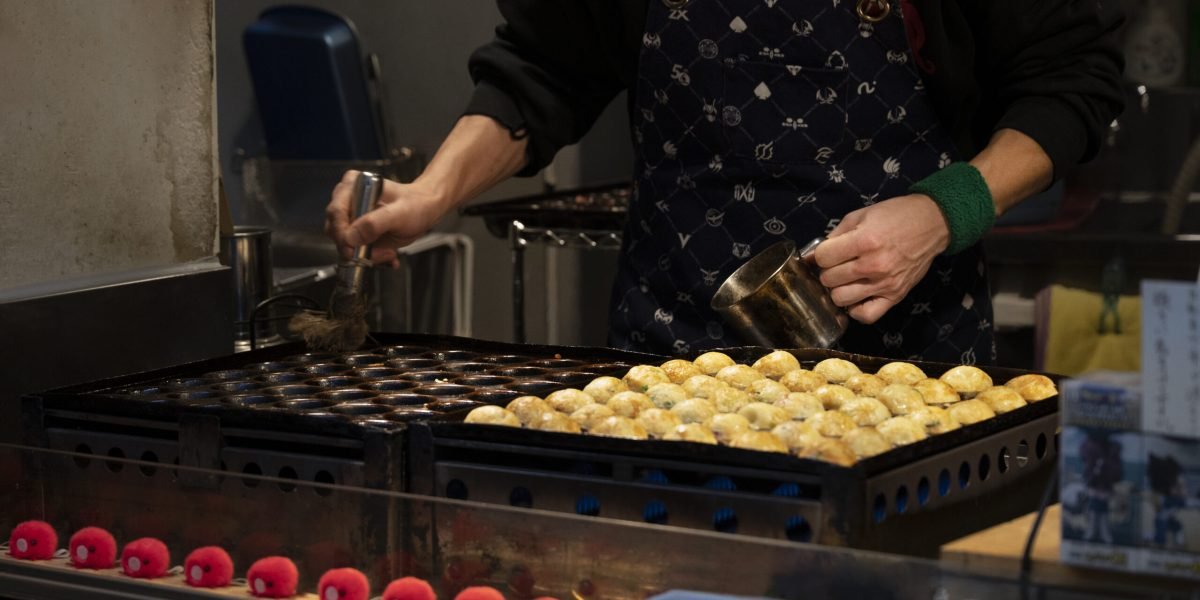 feche-pessoa-cozinhando-comida-de-rua-japonesa